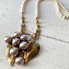 A true One Of A Kind Vintage and New Statement Necklace! A vintage Brooch has a second day in the sun; Lilac Purple Pearl Grapes on a brooch with brass grape Leaves is now a fabulous Pendant, with perfectly Patina-ed Rhinestone chain links off a salvaged vintage necklace, and a Vintage Acrylic Pearl Strand.  Not another soul will be wearing this Necklace other than you! A beautiful one of a kind to layer up for that chic look we love! The necklace clasps on the side in front and measures approximately 25 inches long. Sparkle on, Penelope & Anastasia babes, and follow the meandering journey on IG & FB @PenelopeAndAnastasia for first dibs, Sale announcements, and in person pop up shopping event details!  Xoxo ~ Pamela Vintage Wedding Necklace With Brooch, Vintage Beaded Necklaces For Anniversary, Pearl Strand, Rhinestone Chain, Necklace Clasps, Purple Pearl, Event Details, Shopping Event, Chain Links