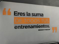 a sign that is on the side of a building with orange and black lettering in spanish