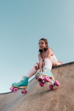 a young woman sitting on top of a skateboard ramp with her feet propped up