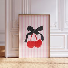 a pink and white striped wall with a black bow holding two cherries