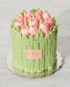 there is a green cake with pink icing in the shape of tulips