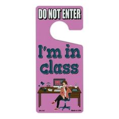 a pink door hanger with the words i'm in class on it and a woman sitting at a desk