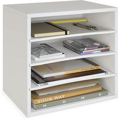 a white book shelf with books on it and a pen resting on top of the shelves