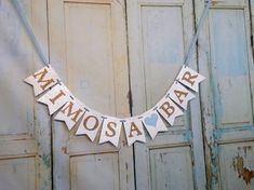 a banner that says atmmossa bar hanging from a door with two hearts on it