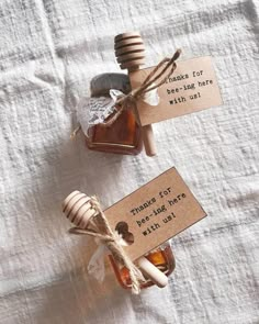 two honey jars with labels on them sitting on a table