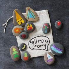 some rocks with writing on them are sitting on the ground next to a drawstring bag