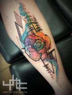 a colorful flower tattoo on the right thigh and lower leg, with an arrow in the middle