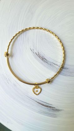 This sweet mustard seed bracelet is a wonderful little piece, perfect for any occasion. The tiny mustard seed is suspended in glassy resin in a tiny textured gold heart. A wonderful reminder to keep the faith. Adjustable Dainty Gold Bracelet With Heart Charm, Gold Bracelets With Heart Pendant Charms, Gold Charm Bracelet With Heart Charm For Mother's Day, Gold Heart Bracelet With Charms For Mother's Day, Yellow Gold Heart Jewelry For Friendship, Mother's Day Gold Heart Bracelet With Charms, Gold Heart Charm Bangle Bracelet, Gold Heart Charm Bracelet For Mother's Day, Gold Bangle Charm Bracelet With Heart Charm