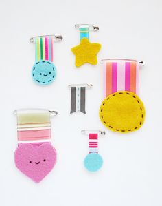 four clips with different designs on them and one has a star, two are hearts, the other is a medal