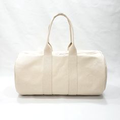 a white canvas duffel bag on a white background