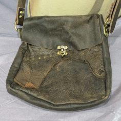 This large shoulder bag is made using scrap leather from other projects, riveted together to make interesting patterns. Sized to fit tablets, phones, wallets, and more, this unique bag is sure to catch the eye. Roughly 11" (28am) tall x 9" k23cm) wide, with a 2" (5cm) gusset. Vintage Leather Bags With Hardware Details, Distressed Brown Bag With Adjustable Strap For Daily Use, Distressed Brown Bag With Adjustable Strap For Everyday Use, Everyday Distressed Brown Bag With Adjustable Strap, Satchel Bag With Hardware For Daily Use, Vintage Leather Bags With Hardware, Daily Use Satchel Bag With Hardware, Leather Shoulder Bag With Snap Closure For Everyday Use, Leather Crossbody Shoulder Bag With Snap Closure