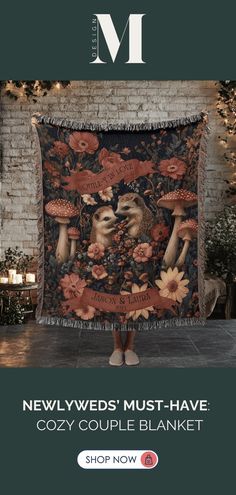 a woman standing in front of a brick wall holding up a blanket with mushrooms on it