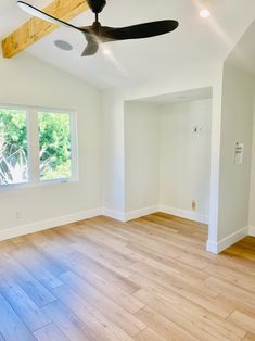 an empty room with hard wood floors and a ceiling fan in the middle of it