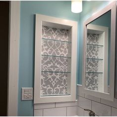 a white sink sitting under a bathroom mirror next to a medicine cabinet with glass shelves