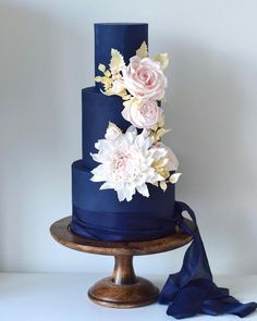 a three tiered blue cake with flowers on top