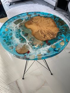 a table with rocks and water on it in the middle of a living room area