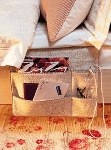 an open purse sitting on top of a wooden floor next to a bed with pillows