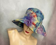 "A big floppy beach hat hand ice tie dyed in blue, green, yellow and red.  It has a drawstring around the inside band to secure fit from the wind.  The hat is by Scala.  The brim is 5\", the crown is 3\", the top diameter is 5 1/2\" and the the inside band is up to 23\" around. Hand or gentle machine wash separately. Excellent condition. Catalog # 8562" Pre-washed Short Brim Summer Hats, Pre-washed Summer Hat With Short Brim, Pre-washed Brimmed Summer Hat, Summer Short Brim Pre-washed Hat, Summer Pre-washed Short Brim Hats, Blue Bucket Hat For Outdoor Beach Season, Adjustable Pre-washed Bucket Hat, Bohemian Bucket Hat For Spring Festival, Bohemian Spring Festival Bucket Hat