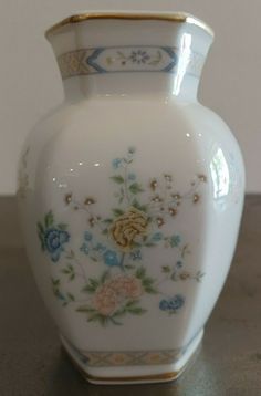 a white vase sitting on top of a table