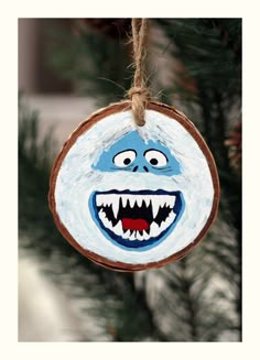 an ornament hanging from a christmas tree decorated with blue and white painted teeth