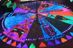 a brightly lit floor with an artistic design in the center and colorful lights on it