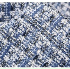 an up close photo of blue and white tweed fabric with black stitching on it