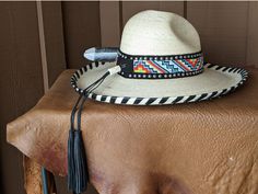 I fashioned this hat after being inspired by the intricate Native American Indian headdresses. This is a palm leaf Gus hat body . It has a 4" brim and a 5 1/4" crown. It is hand laced in black leather lace. The hatband has a base of black suede that is then decorated with two rows of nailspots and finished with this incredibly colorful beaded hatband. Black tassels for that extra accent. And check out the Harris Hawk feather which is actually a turkey feather that has been trimmed and hand paint Adjustable High Crown Sun Hat For Vacation, Artisan Toquilla Straw Hat For Rodeo, Adjustable Brimmed Costume Hat For Vacation, Adjustable Wide Brim Costume Hat For Vacation, Adjustable Brimmed Hat For Vacation, Western Palm Leaf Hat With Curved Brim, Handwoven Flat Brim Hat For Rodeo, Adjustable Brimmed Vacation Hat, Western Handwoven Natural Hat Bands