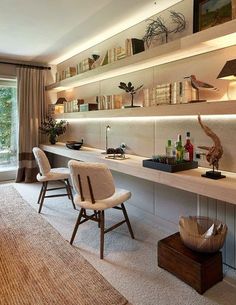 a living room filled with lots of furniture next to a wall mounted book shelf covered in books