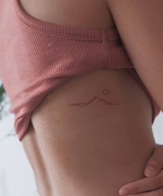 a woman's stomach with a small wave tattoo on it