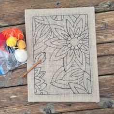 a table topped with yarn and crochet hooks next to a bag filled with knitting needles