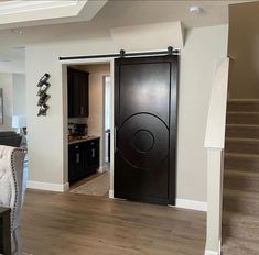 an open door leading to a living room and dining room with stairs in the background