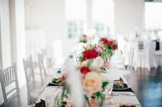 the table is set with white and red flowers