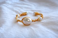 Lolla Jewellery 14K Gold Filled Baroque Freshwater Pearls Bangle, Handmade Luster Gemstone Bangle, Gift Ideas, Gifts for Mom, Dainty Genuine Pearl Bracelets This bangle has seven pearls, with the largest one in the middle being a baroque pearl, surrounded by three natural freshwater pearls on each side.  DETAILS: * Round pearl size: around 10mm * Baroque pearl size: around 23.5mm * Findings: 14k Gold Filled * Bangle Width: around 70mm * Made with 100% hypoallergenic materials What are Baroque Pe Handmade Luxury Pearl Bracelet, Elegant Pearl Bracelet Hand Wrapped For Gift, Elegant Hand Wrapped Pearl Bracelet For Gift, Handmade Elegant Pearl White Bracelets, Handmade Elegant Pearl White Beaded Bracelets, Handmade Adjustable Luxury Pearl Bracelet, Elegant Hand-wrapped Pearl Bracelet, Elegant Handmade Pearl Bangle Bracelet, Handmade Pearl Bangle Bracelets