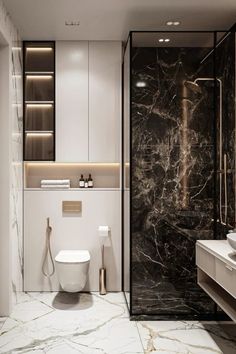 a bathroom with marble walls and flooring, including a white toilet next to a walk in shower