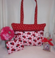 "Designs by Keri® This tote is made with a darling lady bug print and polka dots.  comes with matching coin purse Small 9x15 with 4\" wide bottom and 29\" handles.   coin purse: 4 tall x 6 wide and it has a secure zipper closure. Perfect for small items, coins, credit cards etc. This fun bag is made with a two prints.  The main part is a light pink fabric with big lady bugs and hearts then I matched it with a red with tiny white polka dots.  I added a thick black grosgrain trim with a red rickra Sewing Totes, Light Pink Fabric, Bug Print, Perfect Purse, Lady Bugs, Love Bug, Pink Lady, One Plus, Sweet Heart