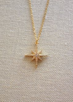 Pretty necklace featuring a gold North Star pendant set with teeny tiny cz's. 18 inch chain. Pendant is approximately 1 inch in diameter. Thanks for stopping by! Elegant Starburst Jewelry As Gift, Elegant Starburst Necklaces For Gifts, Elegant Starburst Jewelry Gift, Celestial Gold Jewelry With Cubic Zirconia, Sparkling Star-shaped Jewelry Gift, Star-shaped Cubic Zirconia Jewelry Gift, Starburst Cubic Zirconia Jewelry Gift, Cubic Zirconia Star Charm Jewelry As Gift, Elegant Starburst Jewelry With Star Charm