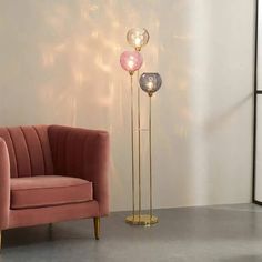 a living room with a pink chair and two floor lamps