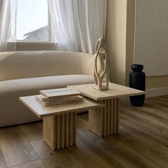 a white couch sitting next to a wooden table on top of a hard wood floor