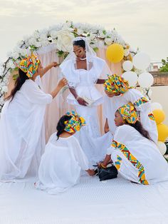 a group of women standing next to each other in front of a white and yellow arch