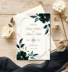 an elegant wedding card with flowers and greenery