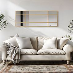 a living room with a couch, mirror and potted plants