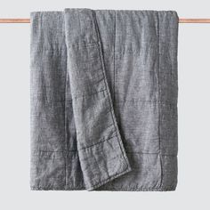 a gray linen blanket hanging on a clothes line