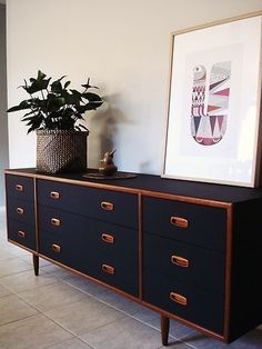 a plant is sitting on top of a dresser in a room with tile flooring