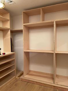 an empty room with wooden shelves and hard wood flooring