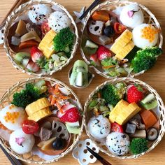 four small baskets filled with different types of food and chopsticks on top of a wooden table