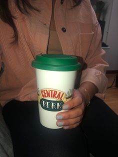 a woman is holding a coffee cup in her hand