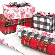 three wrapped presents sitting on top of each other next to a christmas present box and wrapping paper