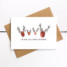 two reindeer heads with antlers on them and the words, we wish you a merry christmas