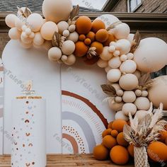 an arch made out of balloons and other decorations on a wooden floor next to a building