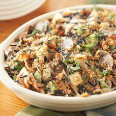 a white bowl filled with food on top of a wooden table